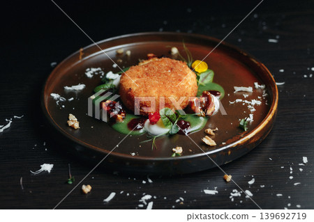 Crispy fried appetizer artfully plated, surrounded by fresh herbs Crispy fried appetizer artfully plated, surrounded by fresh herbs 139692719