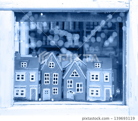 Small houses figurines in a window Small houses figurines in a window 139693119
