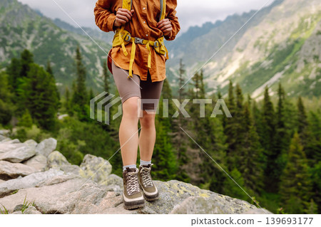 Female legs in hiking boots on hiking trail, on top of mountain outdoors. Nature, relaxation concept Female legs in hiking boots on hiking trail, on top of mountain outdoors. Nature, relaxation concept 139693177