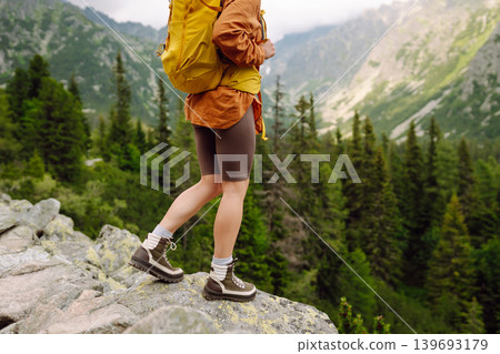Female legs in hiking boots on hiking trail, on top of mountain outdoors. Nature, relaxation concept Female legs in hiking boots on hiking trail, on top of mountain outdoors. Nature, relaxation concept 139693179