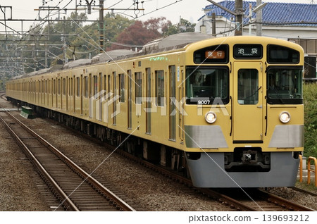 一列黃色的西武線列車駛過車站。 一列黃色的西武線列車駛過車站。 139693212