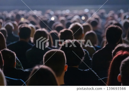 Crowd of people watching live concert in dark venue, backs of heads and blurred stage lights Crowd of people watching live concert in dark venue, backs of heads and blurred stage lights 139693566