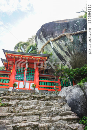 一座神聖的山間神社,有巨大的岩石和一座紅色的神社建築。 一座神聖的山間神社,有巨大的岩石和一座紅色的神社建築。 139694112