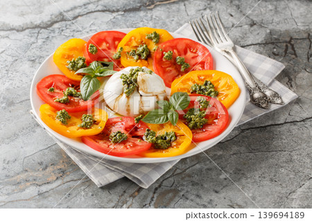 Burrata cheese with fresh tomatoes, basil pesto and balsamic vinegar close-up in a plate. Horizontal Burrata cheese with fresh tomatoes, basil pesto and balsamic vinegar close-up in a plate. Horizontal 139694189