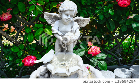 Stone statue surrounded by roses Stone statue surrounded by roses 139694294