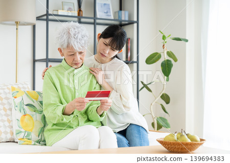 一位年長的母親和她中年的女兒正在看存摺。 139694383