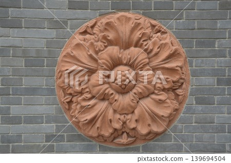 Circular decorative sculptures on a brick wall Circular decorative sculptures on a brick wall 139694504