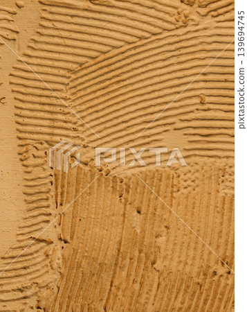 Abstract beige plaster texture with visible trowel marks, rough wall surface pattern for minimalist architectural background and copy space Abstract beige plaster texture with visible trowel marks, rough wall surface pattern for minimalist architectural background and copy space 139694745