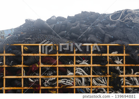 Large Industrial Fishing Nets Piled Inside Yellow Metal Cage Frame Close-up Large Industrial Fishing Nets Piled Inside Yellow Metal Cage Frame Close-up 139694881