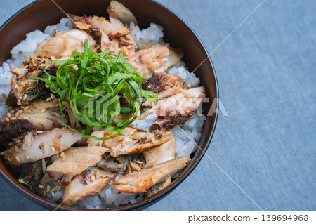 Grilled mackerel rice bowl topped with shredded mackerel and shiso leaves. Grilled mackerel rice bowl topped with shredded mackerel and shiso leaves. 139694968