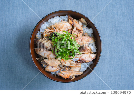Grilled mackerel rice bowl topped with shredded mackerel and shiso leaves. Grilled mackerel rice bowl topped with shredded mackerel and shiso leaves. 139694970