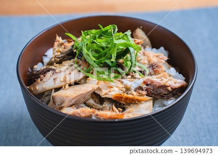 Grilled mackerel rice bowl topped with shredded mackerel and shiso leaves. 139694973