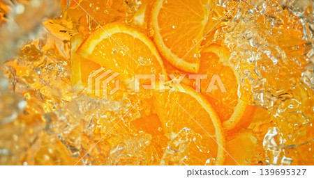 Fresh orange slices falling into sparkling water with bubbles and splashes. Vibrant citrus macro photo, perfect for beverage, freshness, summer, cocktail and healthy lifestyle visuals. 139695327