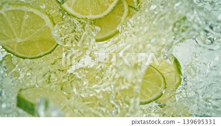 Fresh lime slices falling into sparkling water with bubbles and splashes. Bright green citrus macro photo, perfect for beverage, freshness, summer, cocktail and healthy lifestyle visuals. Fresh lime slices falling into sparkling water with bubbles and splashes. Bright green citrus macro photo, perfect for beverage, freshness, summer, cocktail and healthy lifestyle visuals. 139695331