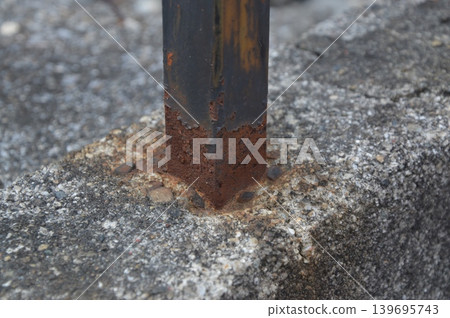 Rusty pillars embedded in concrete Rusty pillars embedded in concrete 139695743