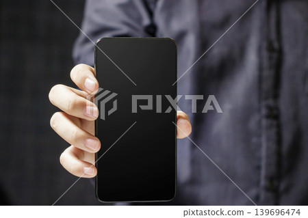 Hand Holding Blank Smartphone with Black Screen. Business and Technology Concept. Communication Device. High quality photo Hand Holding Blank Smartphone with Black Screen. Business and Technology Concept. Communication Device. High quality photo 139696474