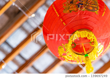 Red traditional Chinese lantern decorated at the wooden arch of the entrance to Lunar New Year festival. Red traditional Chinese lantern decorated at the wooden arch of the entrance to Lunar New Year festival. 139697249