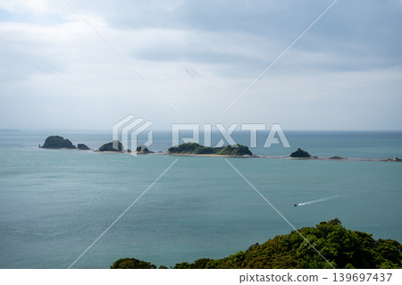 平靜的海面上漂浮著許多小島,構成了一幅美麗的風景。 平靜的海面上漂浮著許多小島,構成了一幅美麗的風景。 139697437