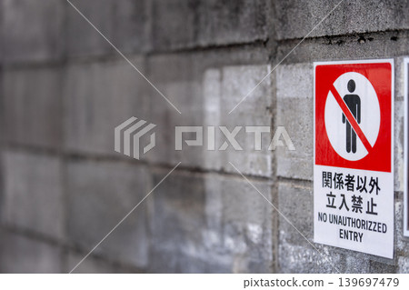 水泥牆上貼著一張告示，上面寫著「未經授權人員禁止入內」。 139697479