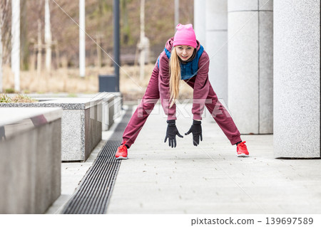 Sporty girl stretching outdoor on city street. Sporty girl stretching outdoor on city street. 139697589