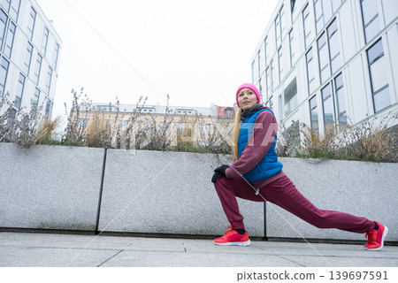 Sporty girl stretching outdoor on city street. Sporty girl stretching outdoor on city street. 139697591
