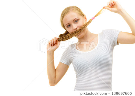 Blonde girl covering her mouth with braid hair Blonde girl covering her mouth with braid hair 139697600