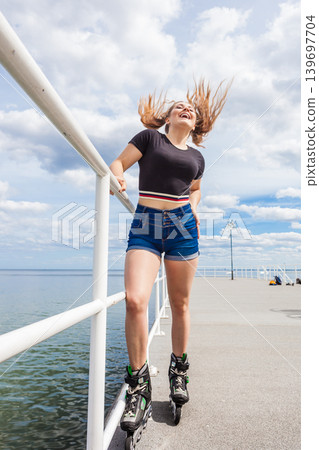 Joyful teen girl wearing roller skates 139697704