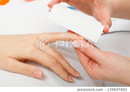 Preparing nails before manicure, beautician file nails Preparing nails before manicure, beautician file nails 139697802
