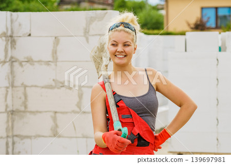 Woman using shovel on constriction site Woman using shovel on constriction site 139697981