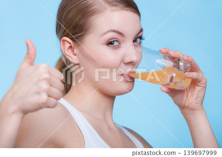 Woman drinking orange flavored drink or juice 139697999