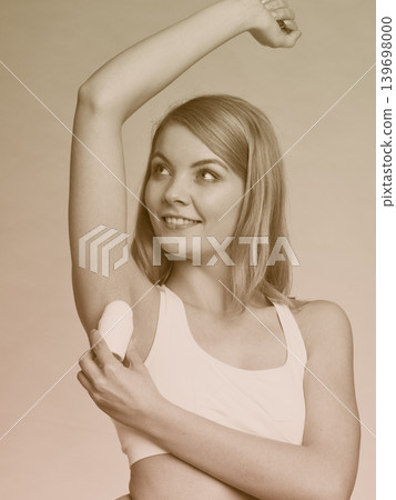 Girl applying stick deodorant in armpit. Girl applying stick deodorant in armpit. 139698000