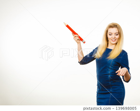 Positive woman holds big pencil in hand Positive woman holds big pencil in hand 139698005