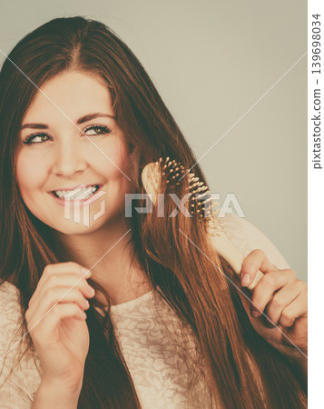 Happy woman brushing her hair Happy woman brushing her hair 139698034