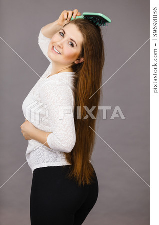 Happy woman brushing her hair Happy woman brushing her hair 139698036