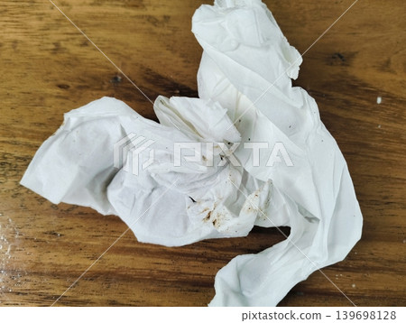 Crumpled and dirty used tissue paper on wooden table Crumpled and dirty used tissue paper on wooden table 139698128