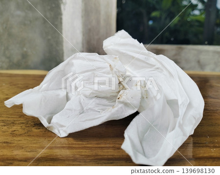 Crumpled and dirty used tissue paper on wooden table Crumpled and dirty used tissue paper on wooden table 139698130