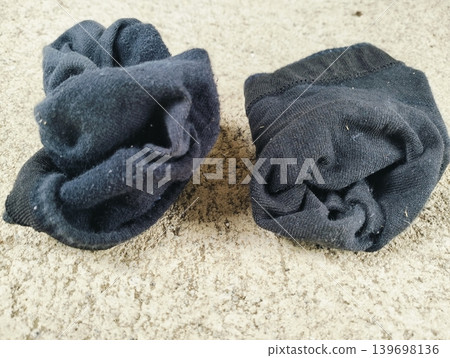 A pair of dirty, smelly black gym socks lying on the floor A pair of dirty, smelly black gym socks lying on the floor 139698136