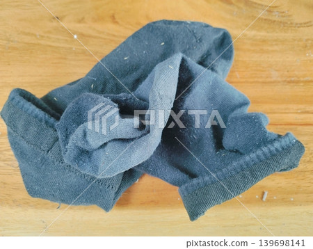 A pair of dirty, smelly black gym socks lying on the floor A pair of dirty, smelly black gym socks lying on the floor 139698141