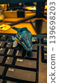 Cute Dinosaur Toy On Computer Keyboard With Cinematic Office Lighting Background 139698203
