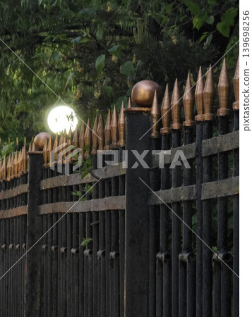 Wrought iron fence with golden spikes. Wrought iron fence with golden spikes. 139698256