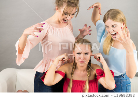 Woman being bullied by two females Woman being bullied by two females 139698398