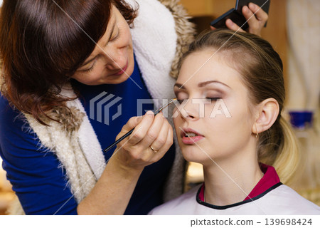 Woman getting eyes make up done by artist Woman getting eyes make up done by artist 139698424
