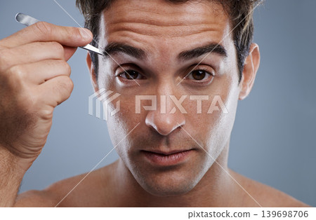 Man, portrait and tweezers for eyebrows or wellness for face grooming, hygiene or grey background. Male person, tools and hair removal for healthy morning routine or studio, treatment or mockup space Man, portrait and tweezers for eyebrows or wellness for face grooming, hygiene or grey background. Male person, tools and hair removal for healthy morning routine or studio, treatment or mockup space 139698706