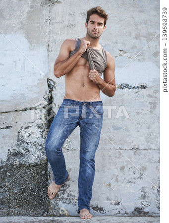 Fashion, city and portrait of man by wall in trendy, casual and stylish outfit in nature. Serious, confidence and full length of attractive young male model undress with cool style by in town. Fashion, city and portrait of man by wall in trendy, casual and stylish outfit in nature. Serious, confidence and full length of attractive young male model undress with cool style by in town. 139698739