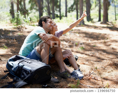 Couple, hiking break and travel in nature for outdoor sightseeing, adventure and wellness journey in forest. Happy man and woman relax on ground and talking of trekking destination with backpack 139698750