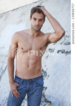 Man, portrait and fitness body with confidence, stomach and wellness outdoor by a wall. Summer, workout and smile of a male model from Brazil with strong arms, torso and topless with abs and relax Man, portrait and fitness body with confidence, stomach and wellness outdoor by a wall. Summer, workout and smile of a male model from Brazil with strong arms, torso and topless with abs and relax 139698757