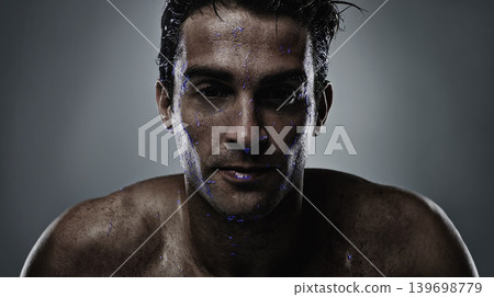 Portrait, man and water with skincare, sweating and dermatology on a grey studio background. Face, person and purple liquid with hydration and beauty with morning routine, wet and luminescent with uv 139698779
