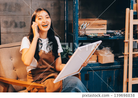 Female artist wears black hat posing near picture indoor the studio Female artist wears black hat posing near picture indoor the studio 139698838