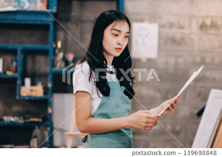 Female artist wears black hat posing near picture indoor the studio Female artist wears black hat posing near picture indoor the studio 139698848