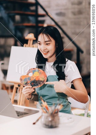 Female artist wears black hat posing near picture indoor the studio Female artist wears black hat posing near picture indoor the studio 139698856